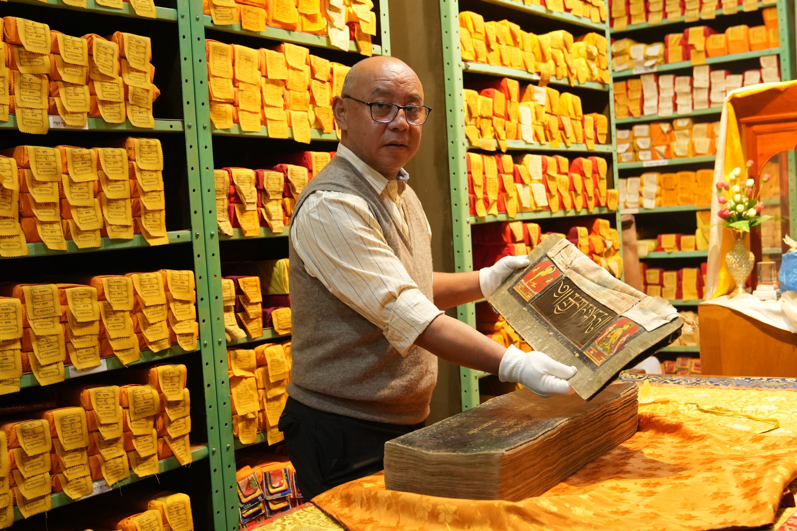 LTWA Library Director Mr. Sonam Topgyal displays a text from the Manuscripts Division.